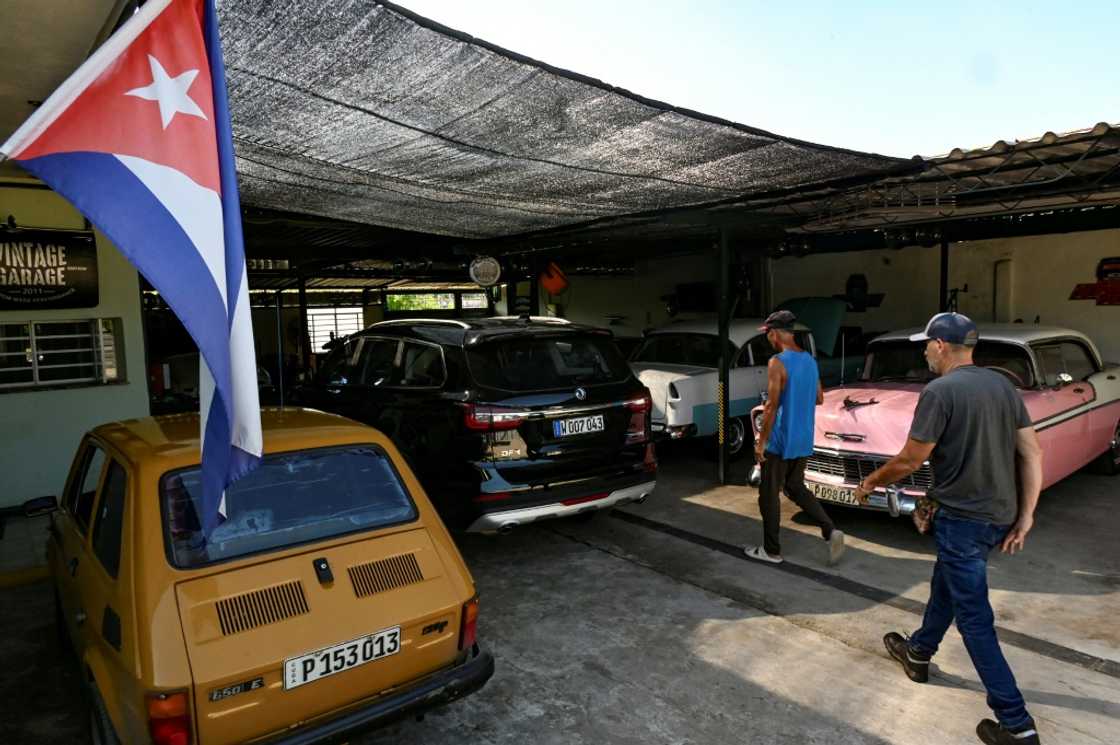 Des Cubains arrivent dans le garage de NostalgiCar, une entreprise privée de transport touristique, à La Havane, le 8 Septembre 2024 Des Cubains arrivent dans le garage de NostalgiCar, une entreprise privée de transport touristique, à La Havane, le 8 Septembre 2024