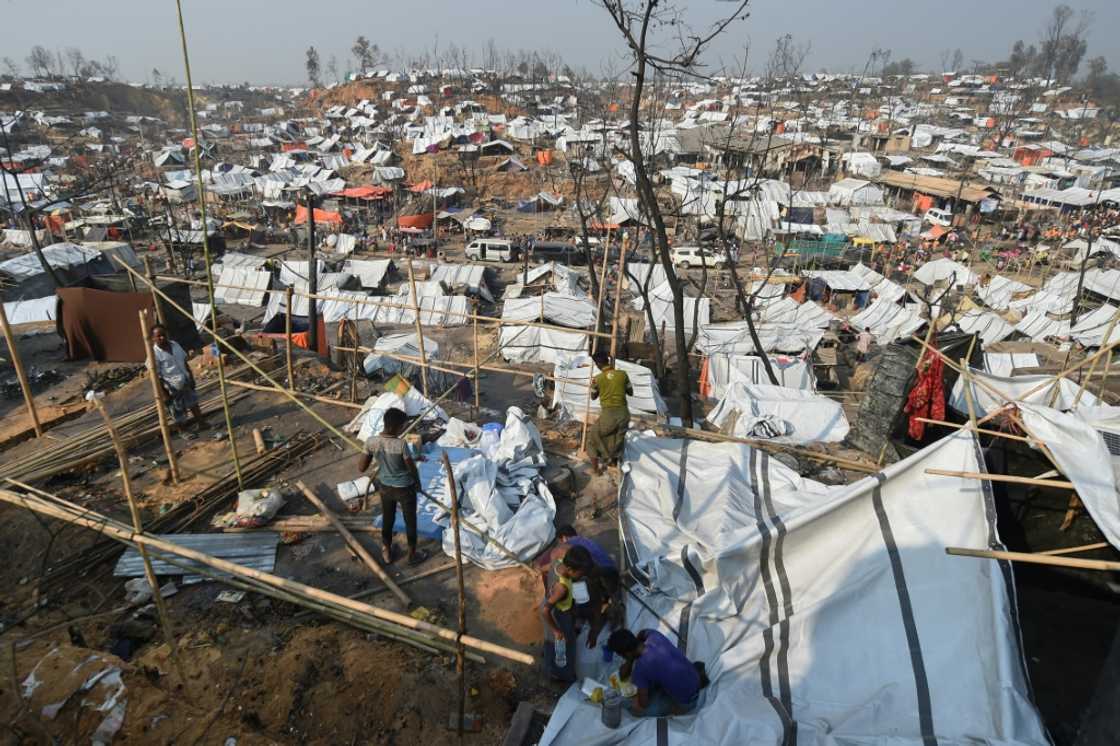Rohingya refugee men build a temporary shelter days after a fire burnt their home at a refugee camp in Ukhia, in the southeastern Cox's Bazar district on March 25, 2021 Rohingya refugee men build a temporary shelter days after a fire burnt their home at a refugee camp in Ukhia, in the southeastern Cox's Bazar district on March 25, 2021