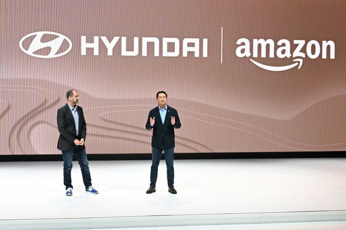 Amazon Vice President Marty Mallick (L) and Hyundai Global President Jose Munoz speak at the media preview day for the Los Angeles Auto Show, on November 16, 2023 Amazon Vice President Marty Mallick (L) and Hyundai Global President Jose Munoz speak at the media preview day for the Los Angeles Auto Show, on November 16, 2023