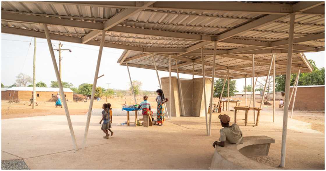 Some of the villagers relax under the shade of the new market