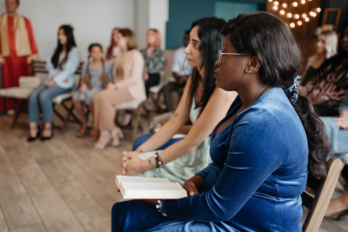 Women sit quietly during a church meeting. Women sit quietly during a church meeting.