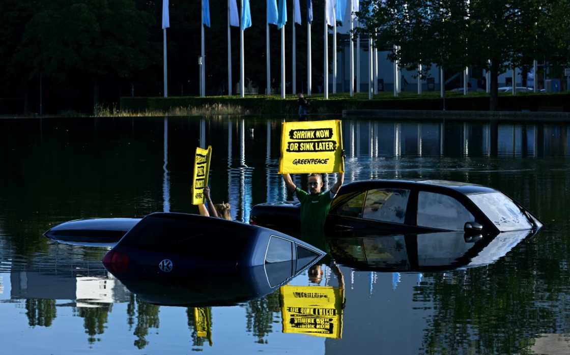 Greenpeace activists submerged three cars in a small lake outside the IAA convention centre