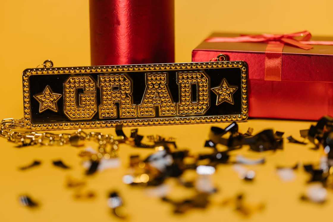 A wrapped gift and plaque engraved with the words 'grad' A wrapped gift and plaque engraved with the words 'grad'