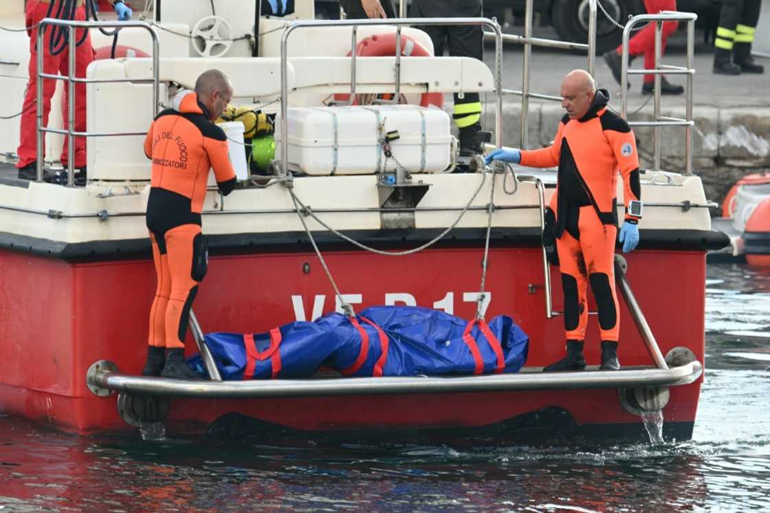 Divers bring a body back from the luxury yacht  Bayesian after it sank killing seven people