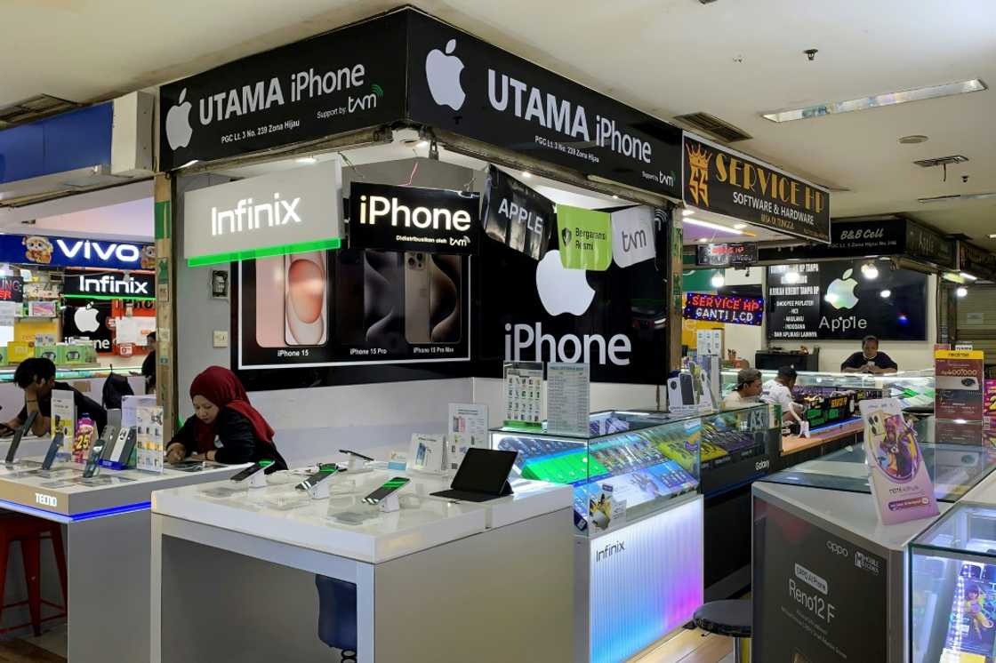 Vendors wait for customers at a mobile phone shopping centre in Jakarta