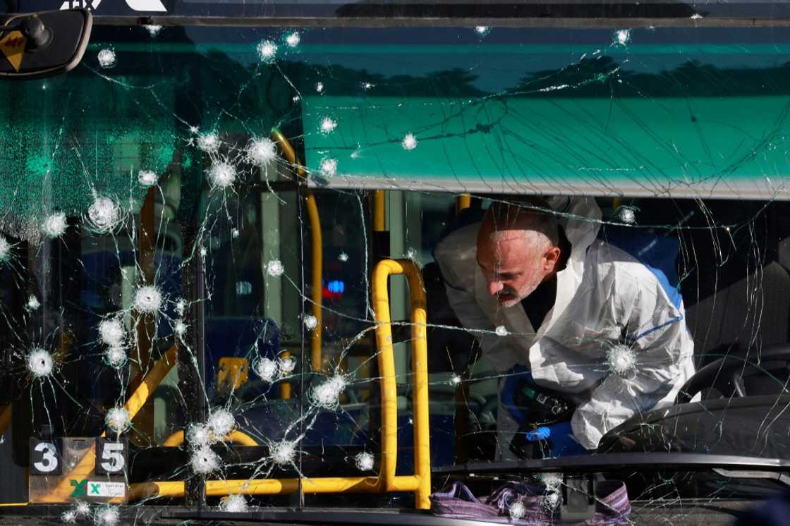 An Israeli forensic scientist inspects the inside of a bus damaged in one of the twin blasts that hit Jerusalem early Wednesday An Israeli forensic scientist inspects the inside of a bus damaged in one of the twin blasts that hit Jerusalem early Wednesday