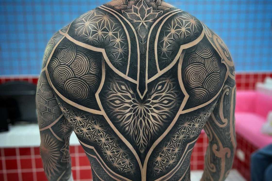 A man has his back covered with a mandala geometric dotwork tattoo A man has his back covered with a mandala geometric dotwork tattoo