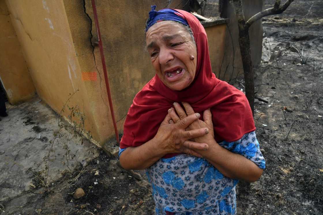 An elderly Algerian woman reacts in front of the ruins of her home, destroyed in a wildfire in the city of El-Kala An elderly Algerian woman reacts in front of the ruins of her home, destroyed in a wildfire in the city of El-Kala