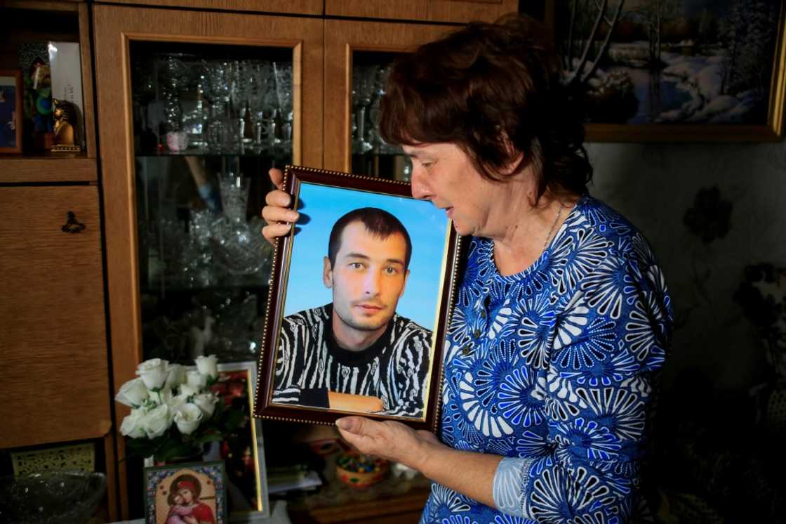 Galina Inkina cries holding a portrait of her late son, Denis, killed in a Kazakh mine Galina Inkina cries holding a portrait of her late son, Denis, killed in a Kazakh mine