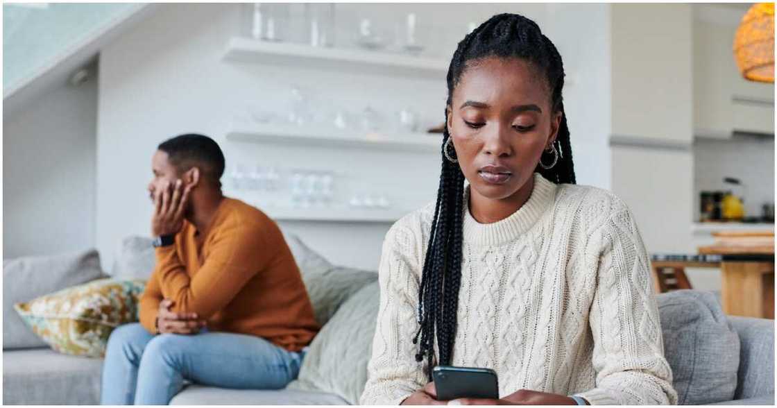 Photo of lady staring at her phone away from her boyfriend