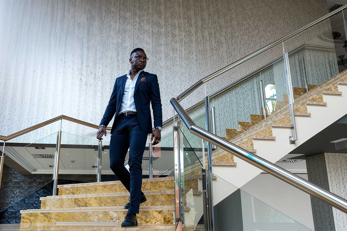 A male entrepreneur looks away while moving downstair