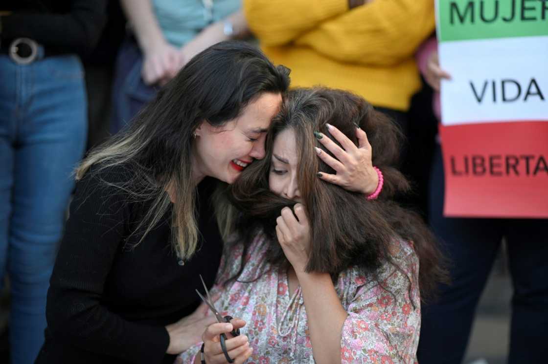 A protester cries as another cuts her hair during a demonstration in support of Kurdish woman Mahsa Amini on Saturday in Madrid A protester cries as another cuts her hair during a demonstration in support of Kurdish woman Mahsa Amini on Saturday in Madrid