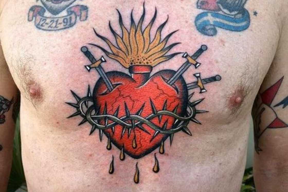 Sacred Heart chest tattoo with swords and thorns