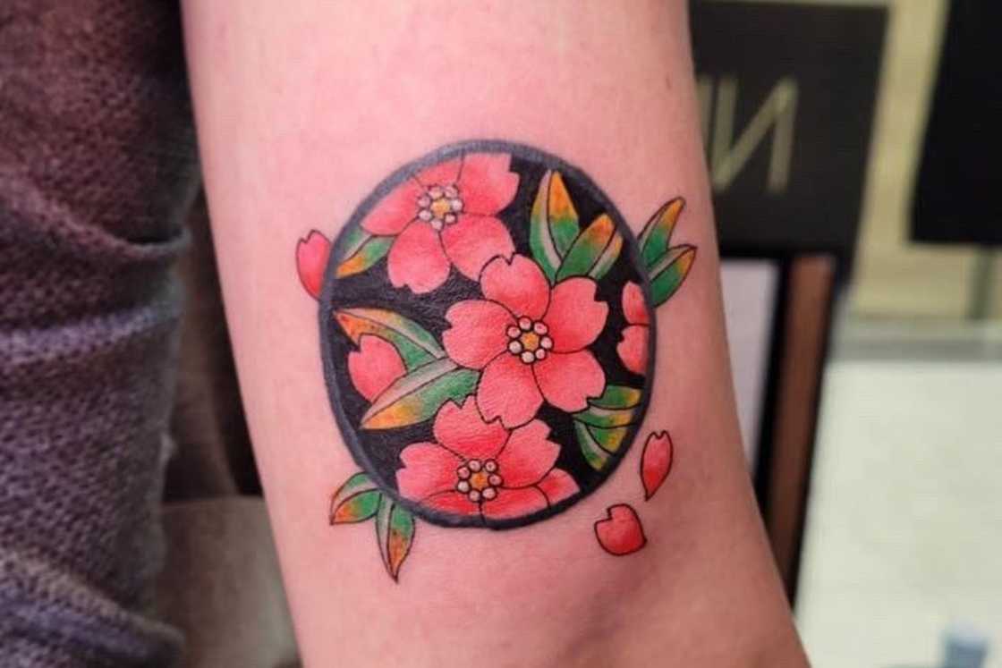 A traditional cherry blossom tattoo on the forearm