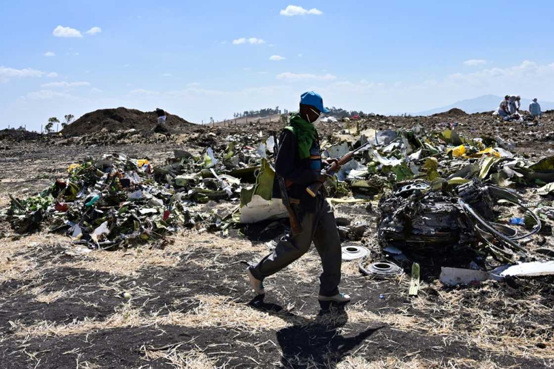A man walks by a pile of twisted debris at the crash site of an Ethiopian Airways Boeing 737 MAX in March 2019 A man walks by a pile of twisted debris at the crash site of an Ethiopian Airways Boeing 737 MAX in March 2019