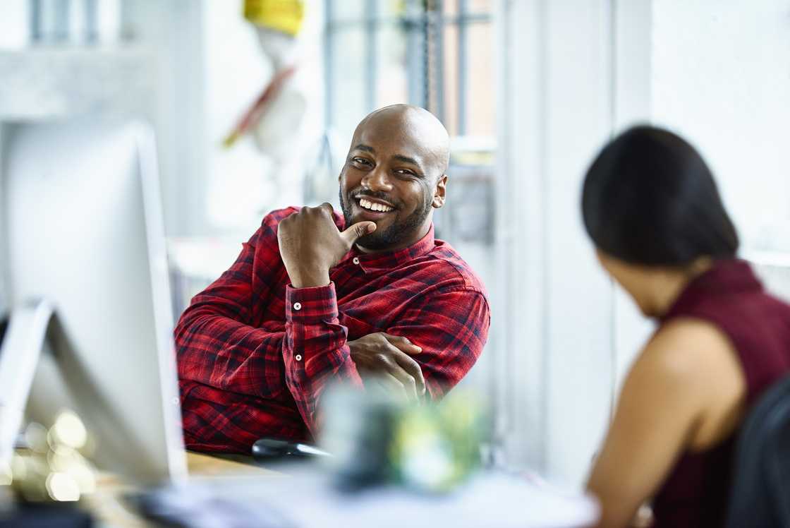 A man and woman talking in an office A man and woman talking in an office
