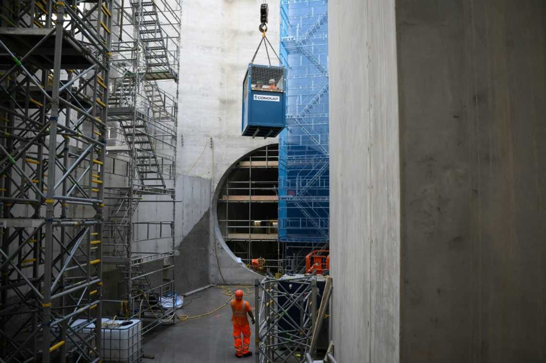 Construction workers are lowered 40 metres (130 feet) down a vertical shaft
