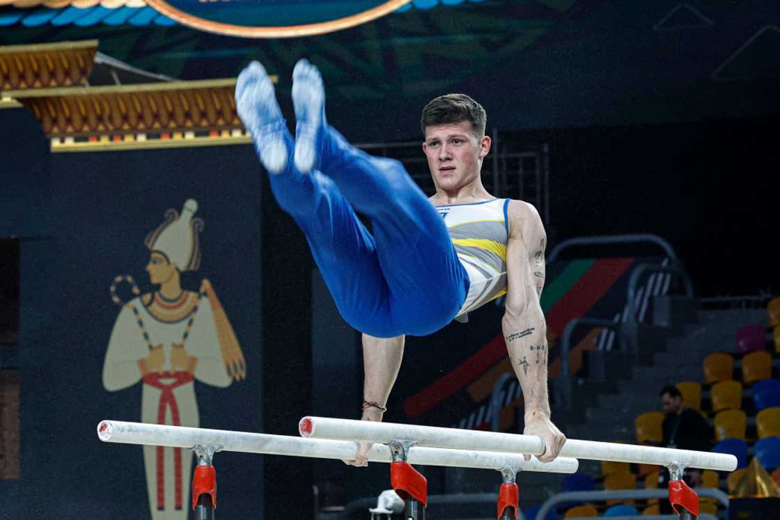 A gymnast performing a handstand on the bars.