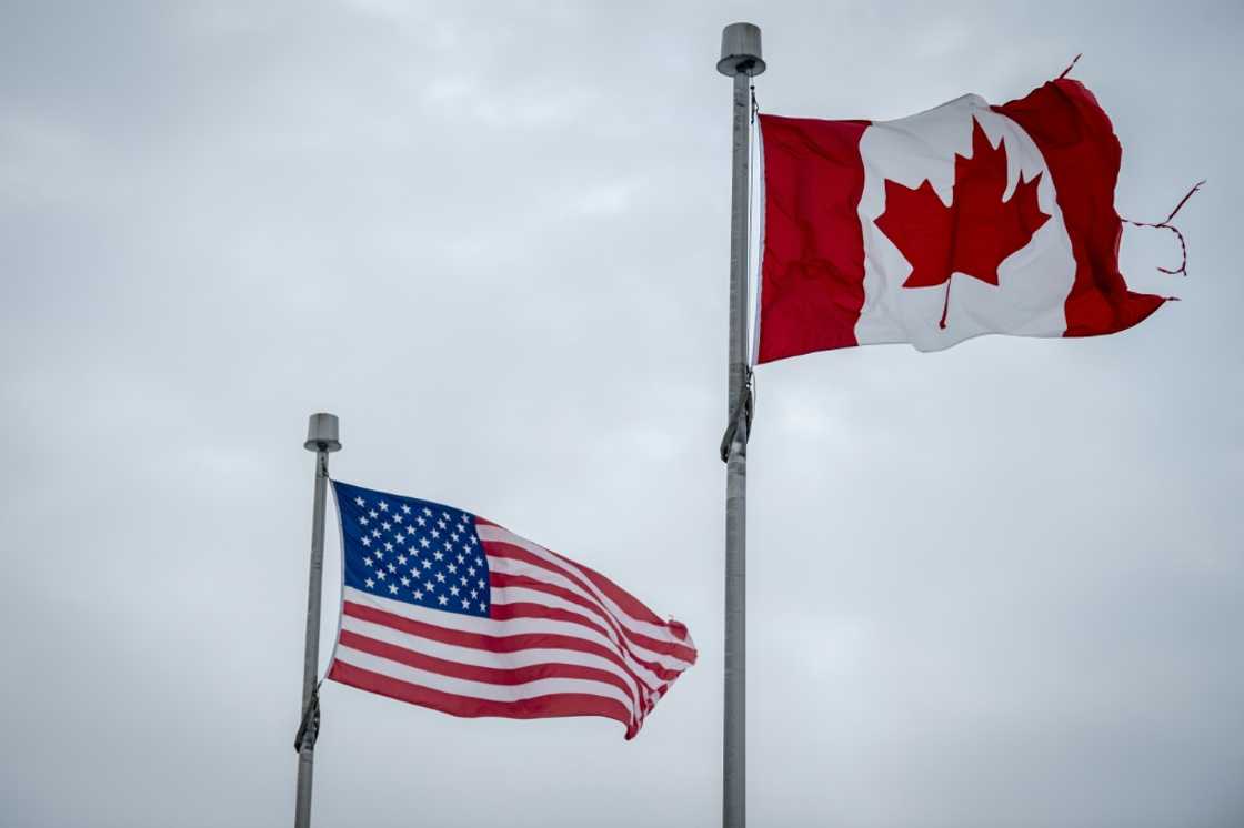 The Canadian and US flags fly near the countries' border in Blackpool, Quebec, Canada The Canadian and US flags fly near the countries' border in Blackpool, Quebec, Canada