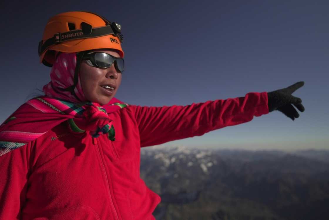 Janet Mamani, an Aymara indigenous woman member of the Climbing Cholitas of Bolivia Warmis, looks satisfied with her night's trek after arriving at the summit of the Huayna Potosi mountain