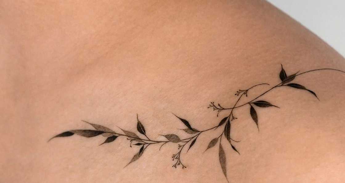 Wraparound black and grey leaves tattoo