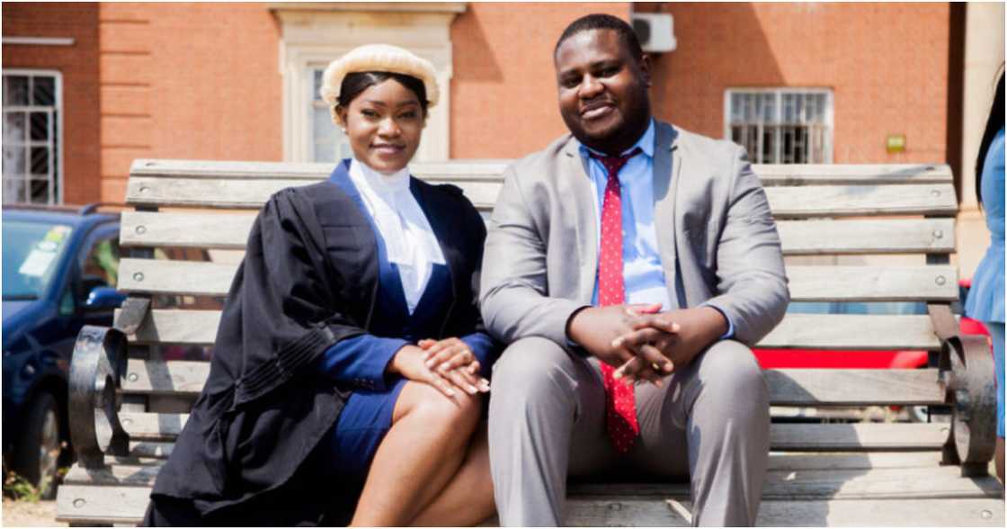 Man poses with his wife as she becomes a lawyer Man poses with his wife as she becomes a lawyer