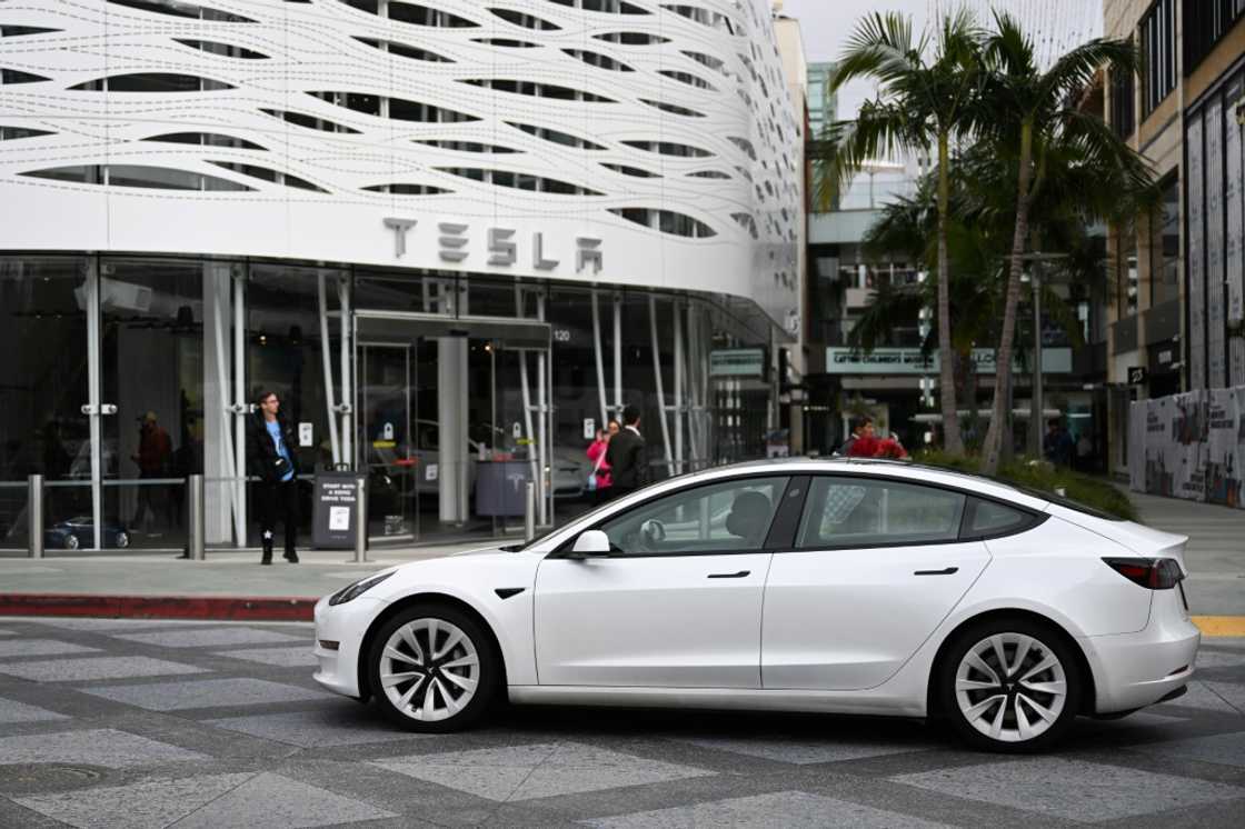 A Tesla electric vehicle drives past the Tesla Inc Santa Monica Place store, in Santa Monica, California