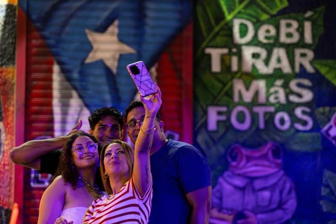 A group of people take a selfie in front of a mural at La Placita de Santurce in San Juan, Puerto Rico on May 12, 2025 A group of people take a selfie in front of a mural at La Placita de Santurce in San Juan, Puerto Rico on May 12, 2025