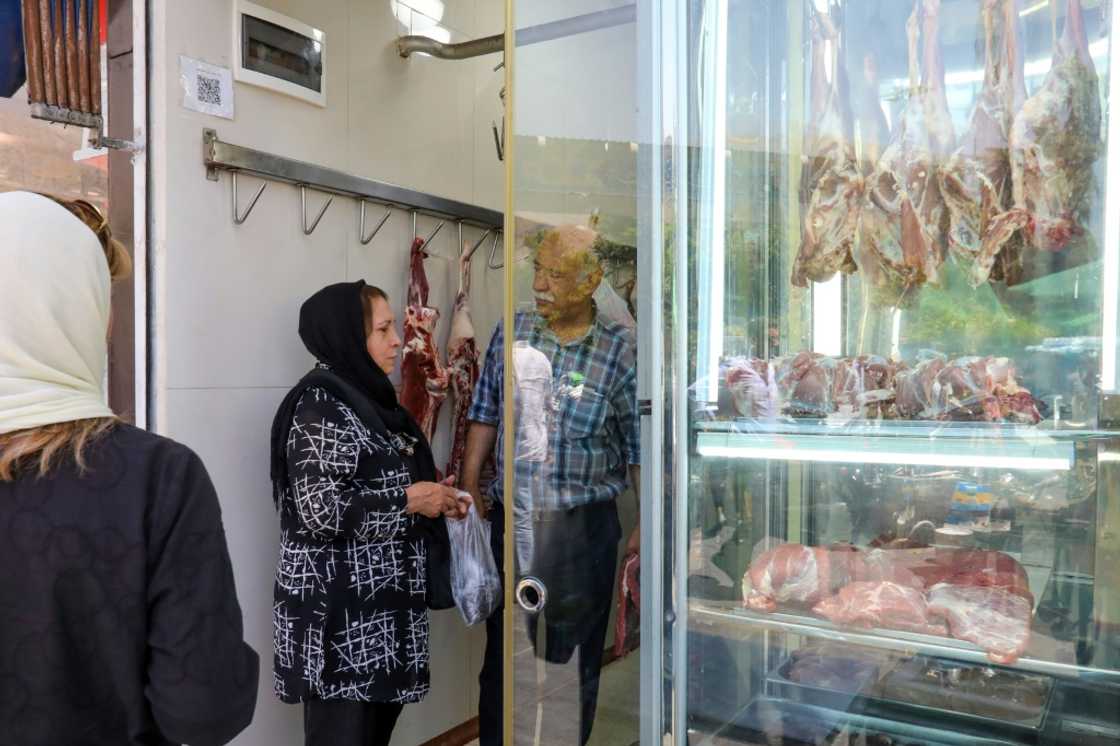 A woman shops at a butcher's in Tehran. Iran has been wrestling with rampant price growth for years, exceeding 30 percent annually every year since 2018, according to the International Monetary Fund