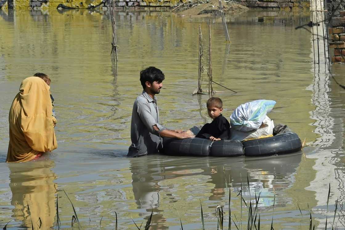 A family wades through a flood-hit area following heavy monsoon rains in Charsadda district of Khyber Pakhtunkhwa A family wades through a flood-hit area following heavy monsoon rains in Charsadda district of Khyber Pakhtunkhwa