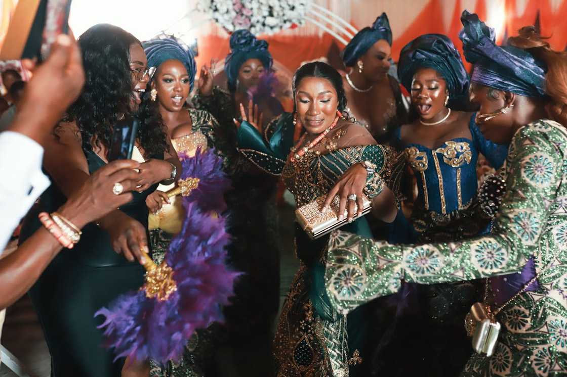 Women in coordinated traditional outfits dancing at a celebration.