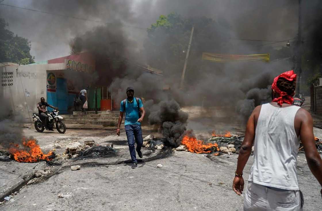Haitians protesting high prices and fuel shortages burn tyres on a street of Port-au-Prince on July 13, 2022 Haitians protesting high prices and fuel shortages burn tyres on a street of Port-au-Prince on July 13, 2022