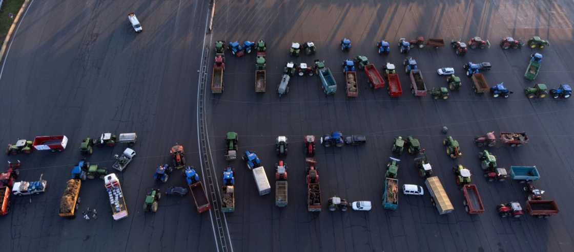 Farmers formed the slogan 'mangez francais' ('eat French') on the A6 motorway outside Lyon Farmers formed the slogan 'mangez francais' ('eat French') on the A6 motorway outside Lyon