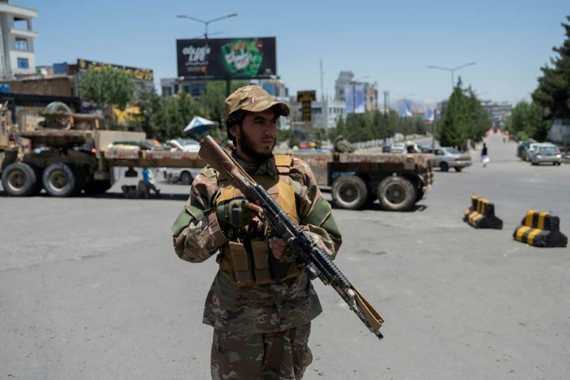 A Taliban fighter stands guard along a blocked street ahead of the council meeting of tribal and religious leaders in Kabul