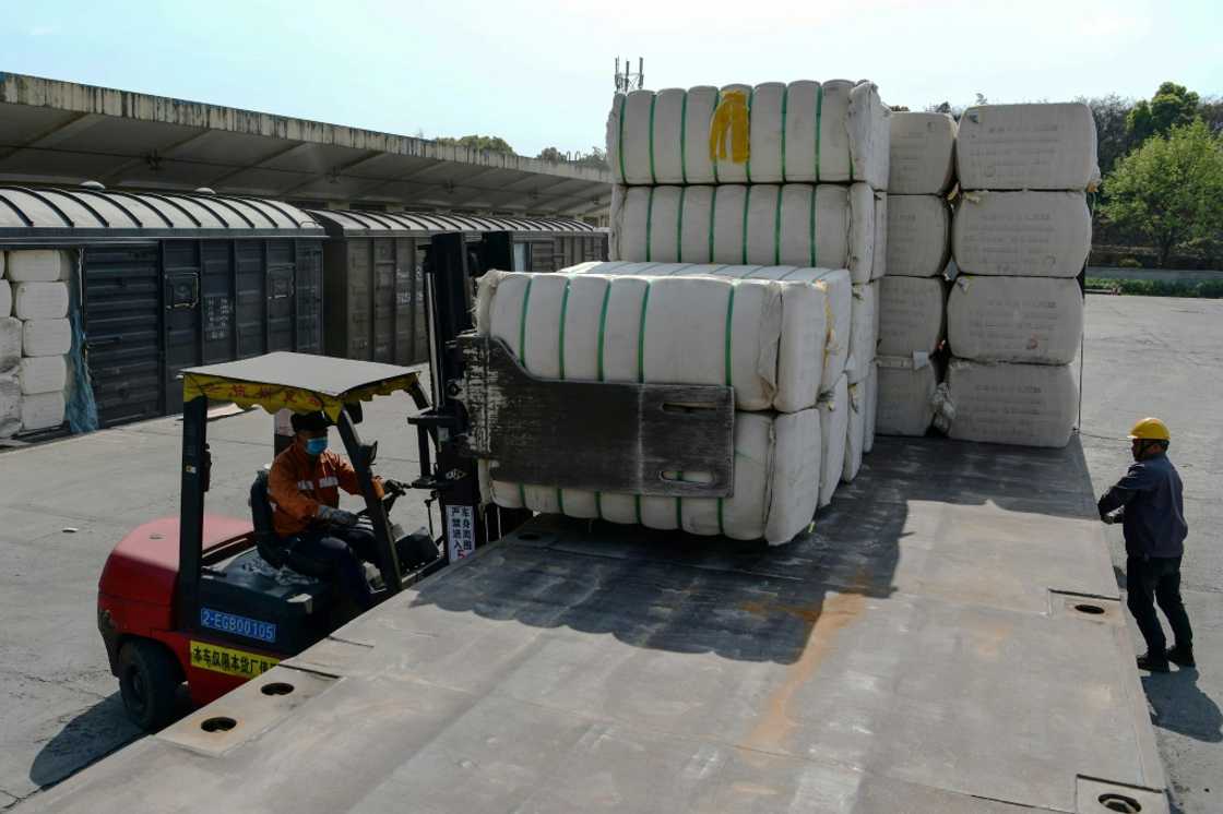 A worker unloads cotton picked from Xinjiang at a railway station in Jiujiang in China's central Jiangxi province in March 2021 A worker unloads cotton picked from Xinjiang at a railway station in Jiujiang in China's central Jiangxi province in March 2021