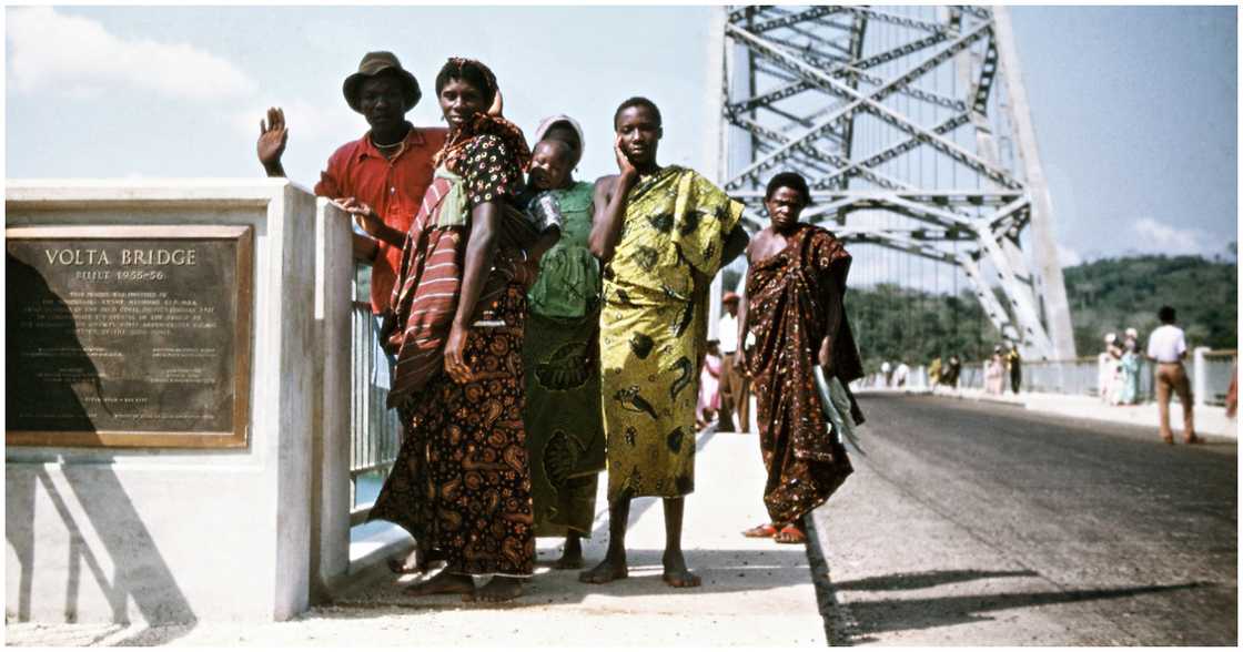 Local residents observe the construction of the Adomi bridge