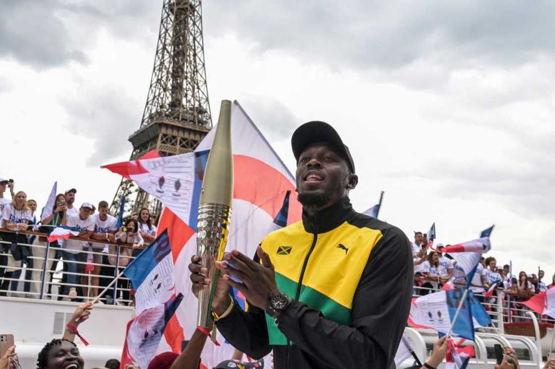 Usain Bolt holding the Olympic torch for Paris 2024 Usain Bolt holding the Olympic torch for Paris 2024