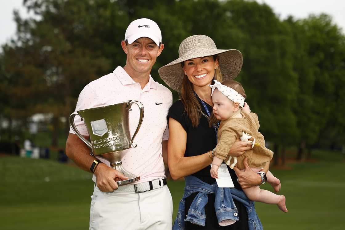 Rory McIlroy (L) celebrates with the trophy alongside his wife Erica and daughter Poppy (R) Rory McIlroy (L) celebrates with the trophy alongside his wife Erica and daughter Poppy (R)