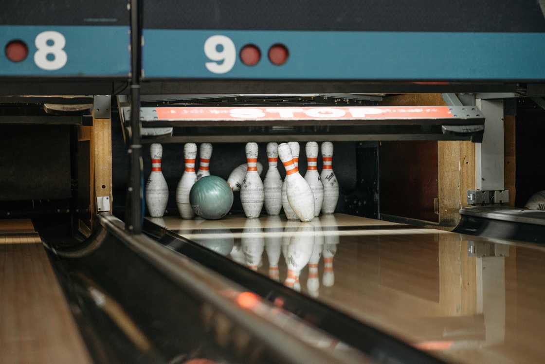 White and red bowling pins with a green bowling ball