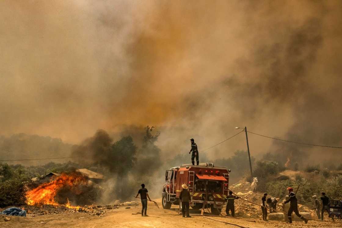 Firefighters battle a blaze raging in Morocco's northern region of Ksar Sghir on July 14 Firefighters battle a blaze raging in Morocco's northern region of Ksar Sghir on July 14