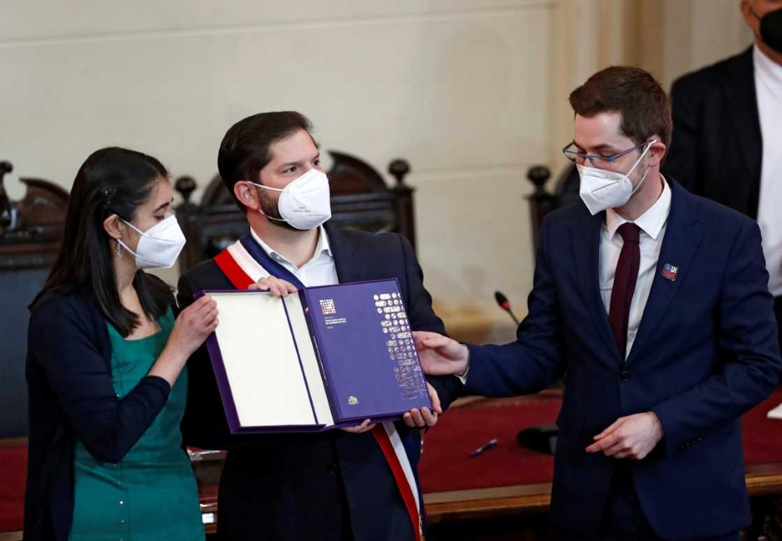 The president and vice-president of Chile's constitutional convention Maria Elisa Quinteros (L) and Gaspar Dominguez (R), respectively, hand the final draft to President Gabriel Boric, at the National Congress in Santiago The president and vice-president of Chile's constitutional convention Maria Elisa Quinteros (L) and Gaspar Dominguez (R), respectively, hand the final draft to President Gabriel Boric, at the National Congress in Santiago