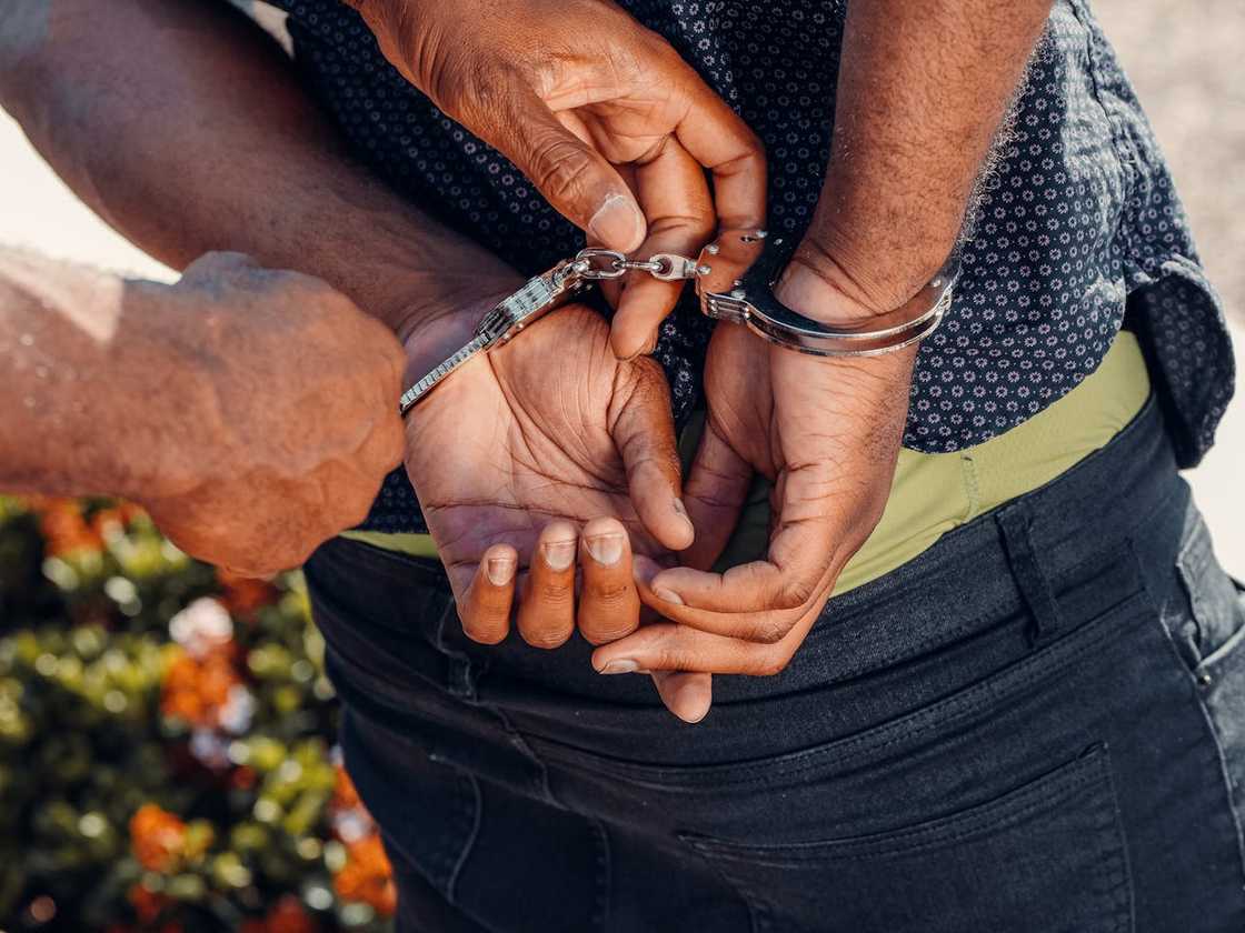 A person is handcuffed with their hands behind their back.