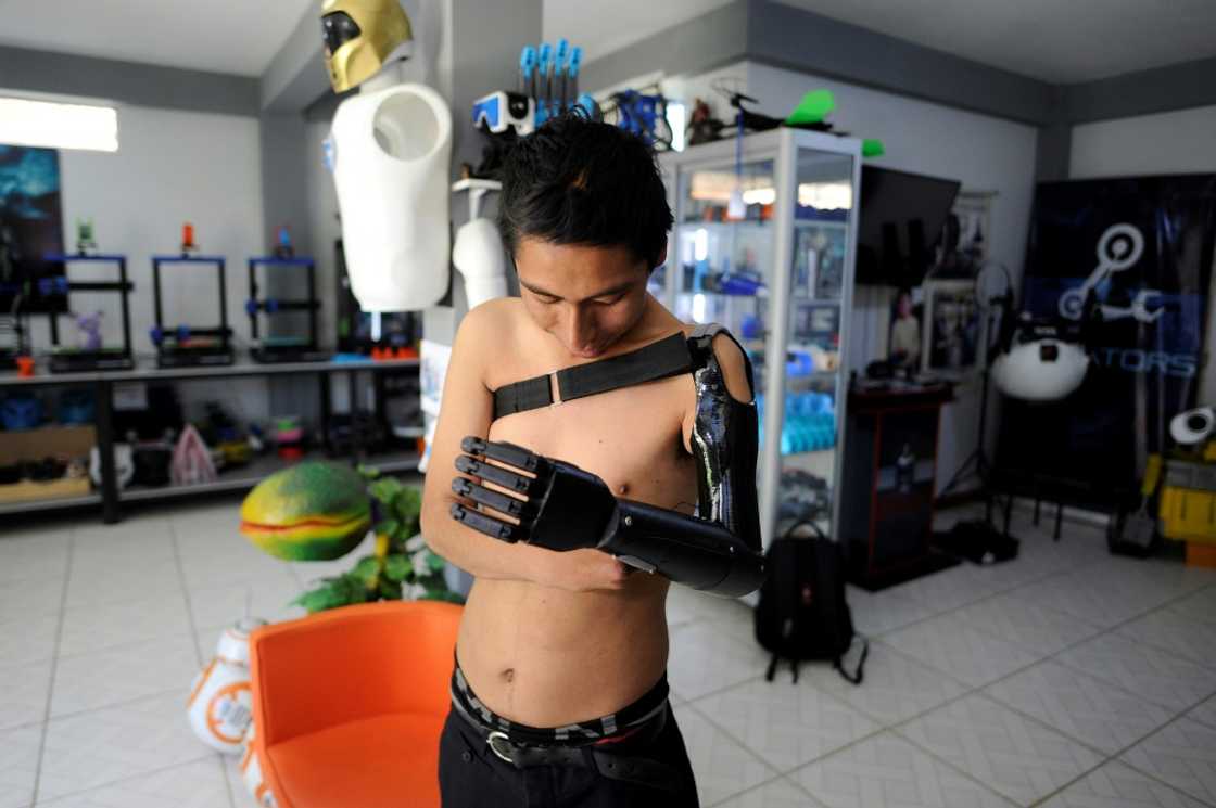 Marco Antonio Nina, 26, who lost his left arm at the age of 14 in a work accident, tests his bionic arm prosthesis that Roly Mamani made for him in his 'Robotics Creators' workshop in Achocalla, Bolivia, on January 8, 2024 Marco Antonio Nina, 26, who lost his left arm at the age of 14 in a work accident, tests his bionic arm prosthesis that Roly Mamani made for him in his 'Robotics Creators' workshop in Achocalla, Bolivia, on January 8, 2024