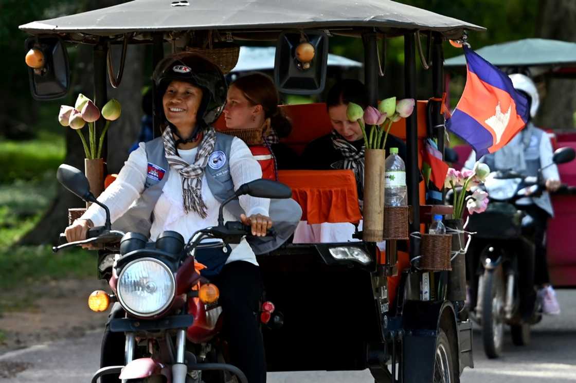 Tuk-tuk driver Kim Sokleang transporting passengers near the Bayon temple at the Angkor complex in Siem Reap province Tuk-tuk driver Kim Sokleang transporting passengers near the Bayon temple at the Angkor complex in Siem Reap province