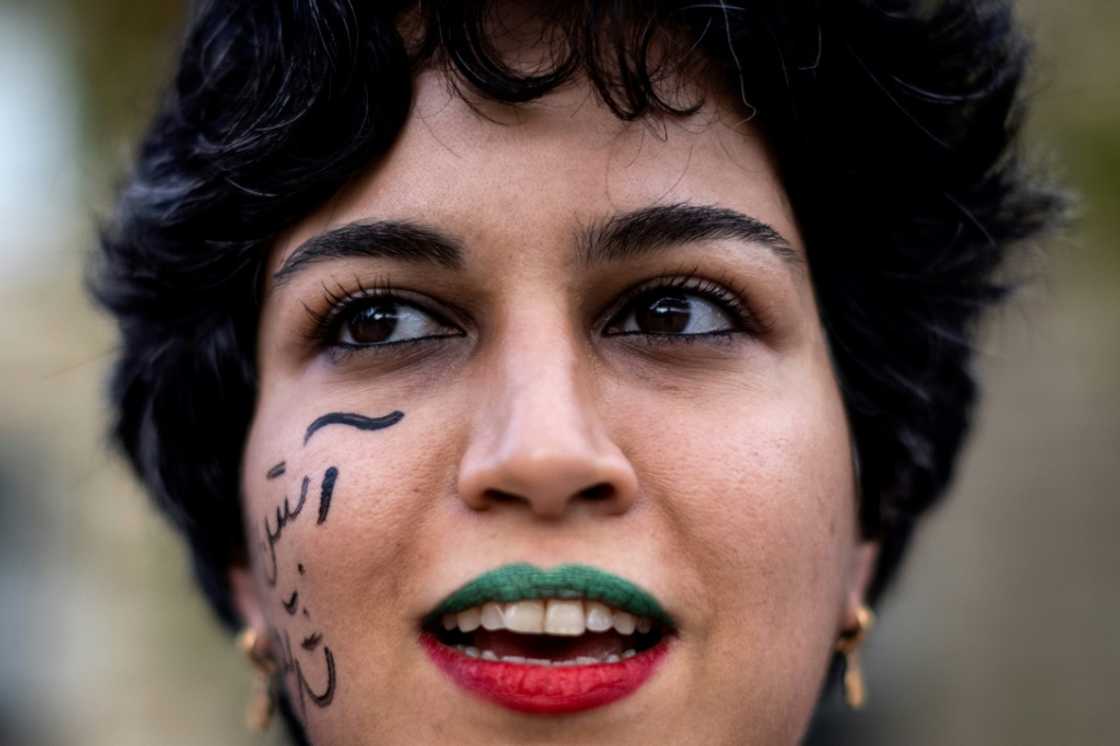 A woman wearing lipsticks in the colours of the Iranian flag takes part in a rally in support of protests in Iran in Paris A woman wearing lipsticks in the colours of the Iranian flag takes part in a rally in support of protests in Iran in Paris