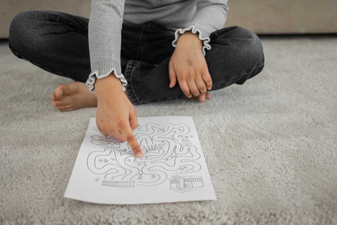 A kid sitting on a rug and playing with a puzzle A kid sitting on a rug and playing with a puzzle