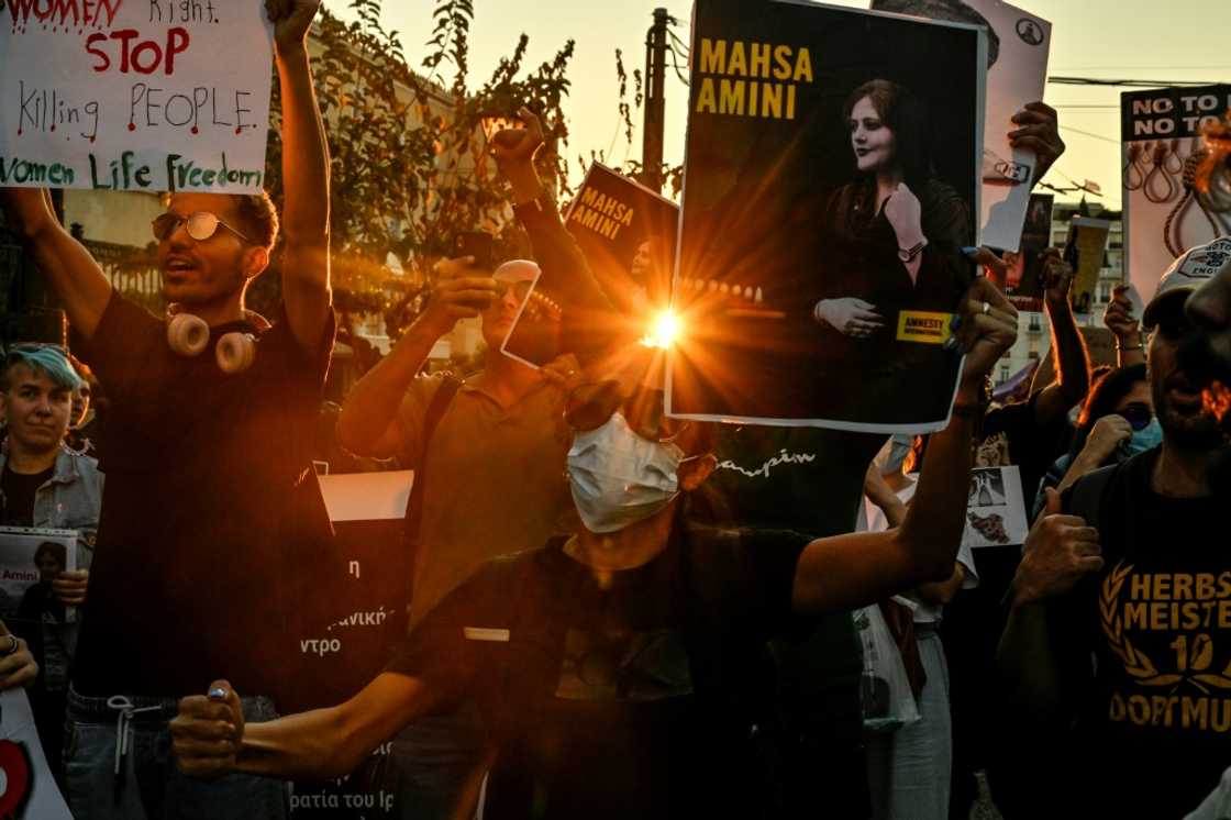 Iranian women in Athens cut their hair in a gesture of solidarity with Amini, brandishig placards reading "say her name!"