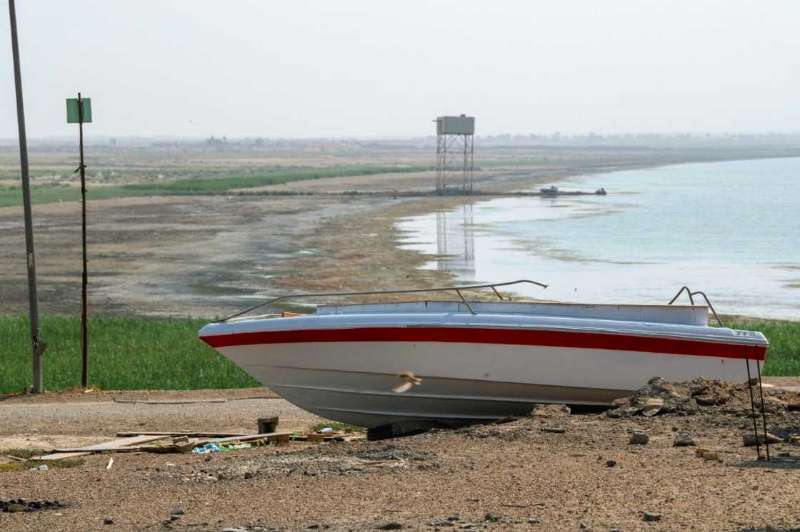 A boat is grounded by the receding shoreline of Iraq's Lake Habbaniyah, affected by a severe four-year drought