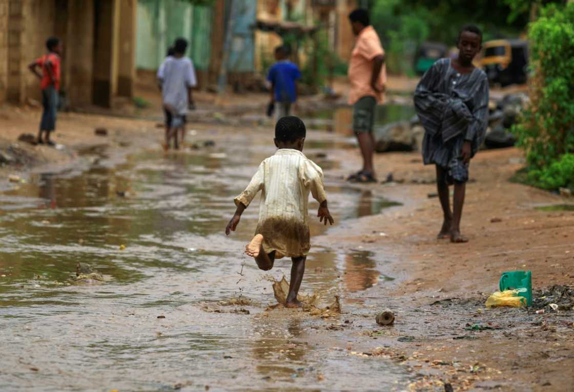 A boy runs through floodwater after a downpour in Sudan's capital Khartoum on August 13, 2022 A boy runs through floodwater after a downpour in Sudan's capital Khartoum on August 13, 2022