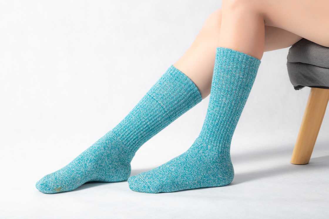 A sitting woman shows off her ribbed pair of socks